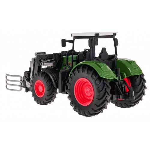 Zelený traktor s drapákem