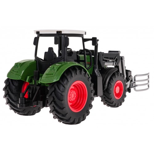 Zelený traktor s drapákem