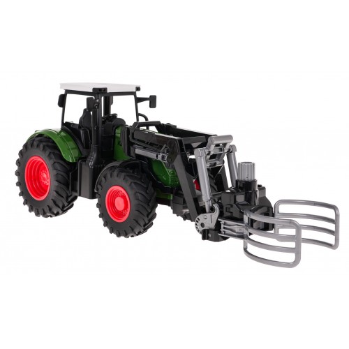 Zelený traktor s drapákem