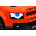 Oranžové vozidlo Land Rover Defender